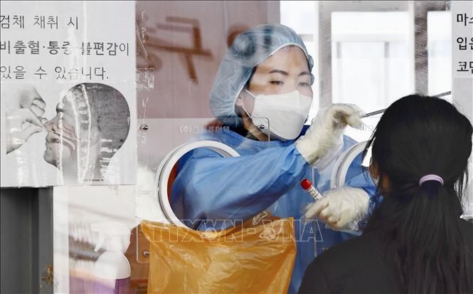 Nhân viên y tế lấy mẫu xét nghiệm COVID-19 cho người dân tại Seoul, Hàn Quốc ngày 26/1/2022. Ảnh: Kyodo/TTXVN