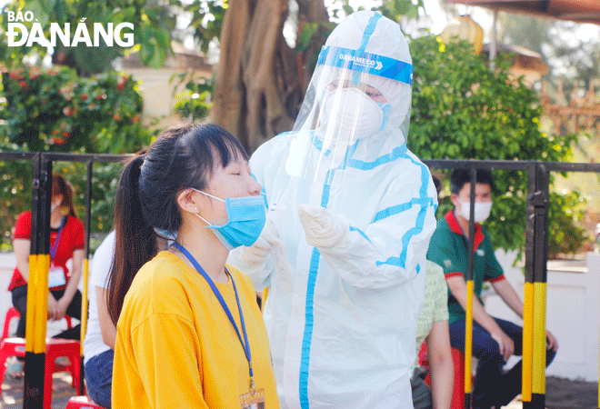 Testing plays a key role in health agency’s efforts to contain and mitigate the COVID-19 pandemic by identifying infected individuals to help prevent further person-to-person transmission of COVID-19. IN PHOTO: Healthcare workers in Son Tra District conducting COVID-19 testing for workers at the Da Nang Industrial Park. Photo: Xuan Dung