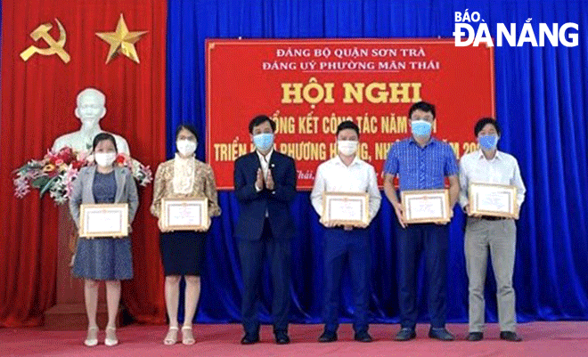 Bí thư Đảng ủy phường Mân Thái (quận Sơn Trà) Đặng Đình Hưởng (thứ ba, trái sang) trao giấy khen cho các đảng viên xuất sắc trong công tác xây dựng Đảng năm 2021.  Ảnh: TRỌNG HUY