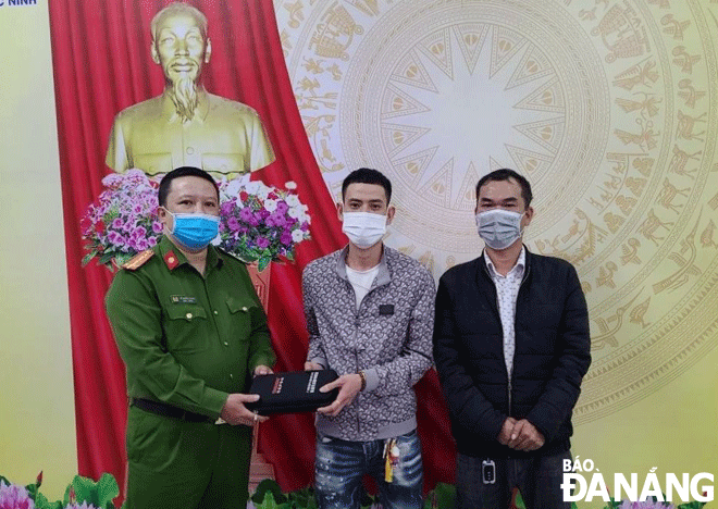 Anh Huỳnh Đức Trí (bìa phải) và đại diện Công an phường Phước Ninh trao trả lại tài sản cho anh Nguyễn Phi Anh (giữa). Ảnh: L.H