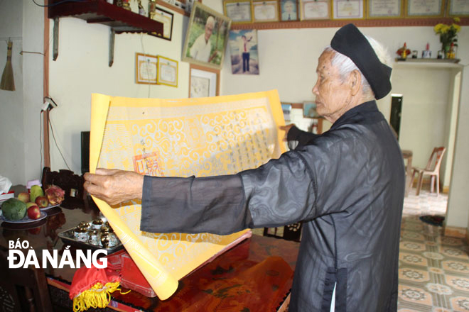Cụ Thái Văn Lịch (92 tuổi) bên tấm sắc phong. Ảnh: T.H