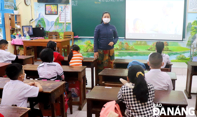 Giáo viên Trường Tiểu học Ông Ích Khiêm (quận Hải Châu) hướng dẫn học sinh về phòng, chống dịch trong ngày đầu trở lại trường. (Ảnh chụp ngày 21-2) Ảnh: NGỌC HÀ
