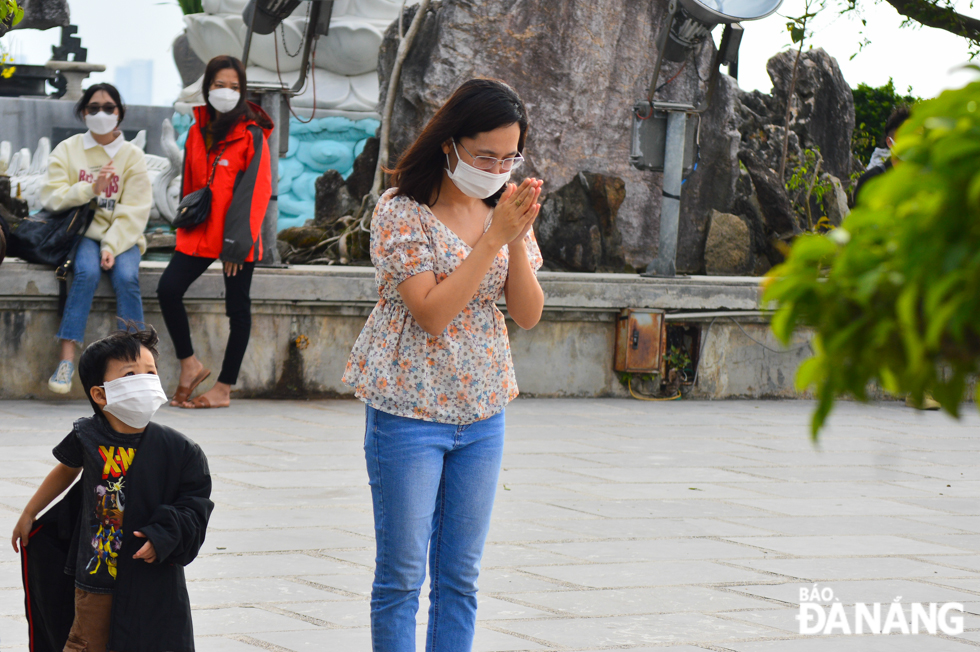 Visitors offer incense in front of the sacred space of the Linh Ung Pagoda to pray for peace in the family.