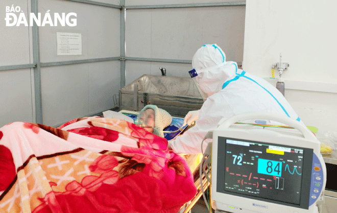 Nhân viên y tế chăm sóc bệnh nhân mắc Covid-19 tại Bệnh viện dã chiến.Ảnh: XUÂN SƠN