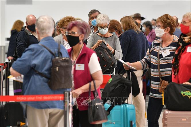 Hành khách đeo khẩu trang tại sân bay quốc tế Sydney, Australia. Ảnh: AFP/TTXVN