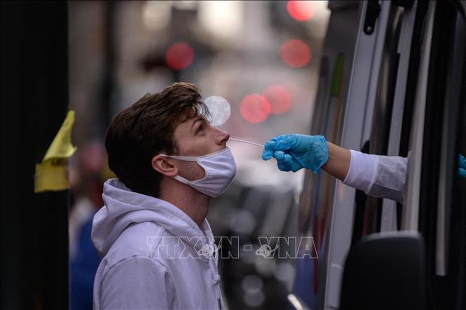 Nhân viên y tế lấy mẫu xét nghiệm Covid-19 cho người dân tại New York, Mỹ. Ảnh: AFP/TTXVN
