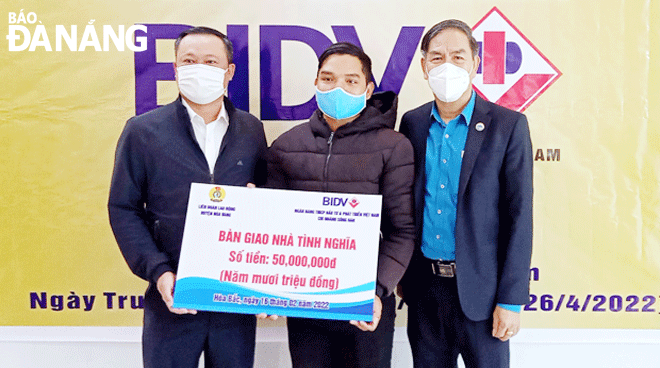 Representatives of the Joint Stock Commercial Bank for Investment and Development of Viet Nam (BIDV) (left) and Hoa Vang Labor Confederation Chairman Huynh Tan (right) hand over finances to build a new house for Mr Phan Van Thai. Photo: H.H