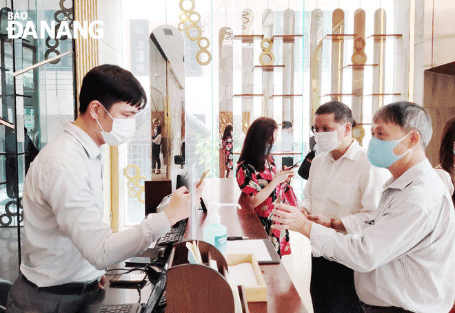 Nhân viên lễ tân (trái) của một khách sạn trên đường Đống Đa (quận Hải Châu) đang làm thủ tục cho khách. Ảnh: NHẬT HẠ	