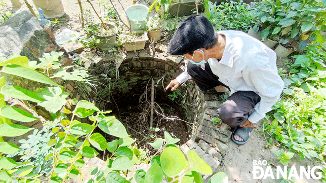 Ông Khương Hưu bên dấu tích giếng cổ chùa Ông, xã Duy Vinh, huyện Duy Xuyên, tỉnh Quảng Nam. Ảnh: XUÂN SƠN