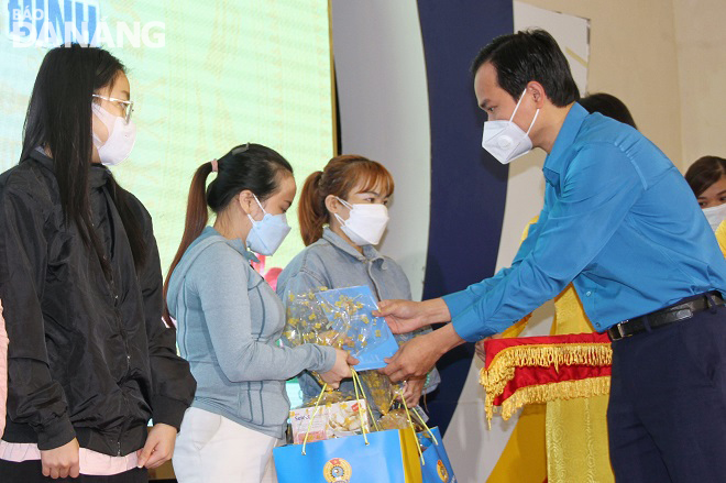 Chủ tịch Liên đoàn Lao động thành phố Nguyễn Duy Minh (bìa phải) trao quà cho nữ đoàn viên đơn thân khó khăn. Ảnh: L.P