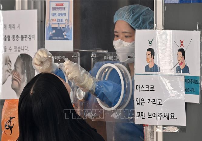 Nhân viên y tế lấy mẫu xét nghiệm Covid-19 cho người dân tại Seoul, Hàn Quốc, ngày 4-3-2022. Ảnh: AFP/TTXVN