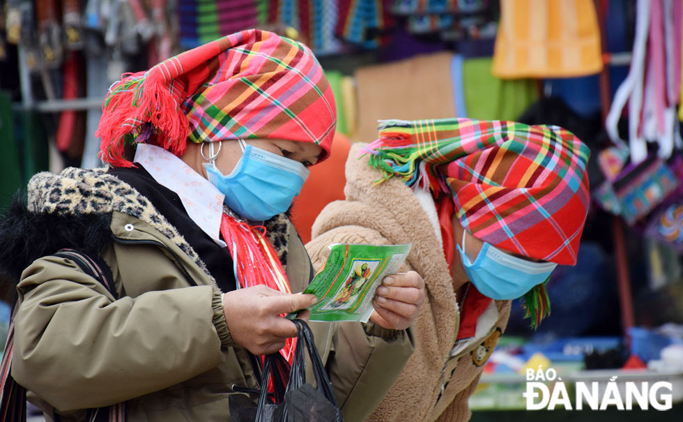 Mong ethnic minority women are seen buying seeds at the market.