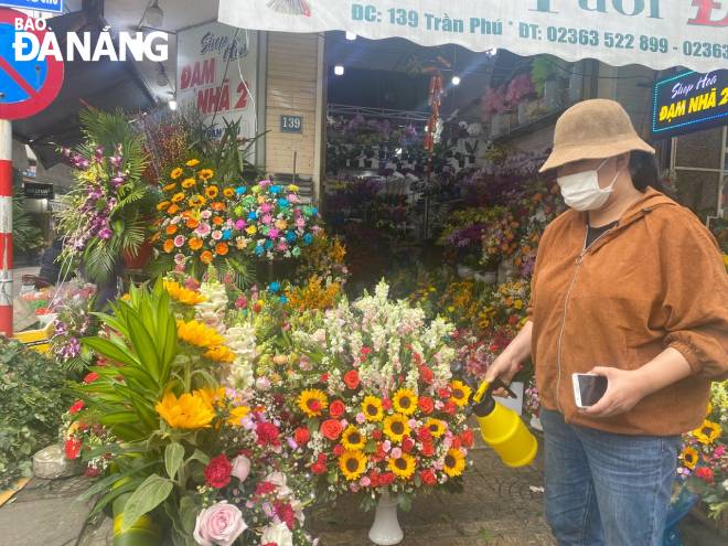 A flower seller refills water constantly to keep flowers fresh. Photo: QUYNH TRANG 