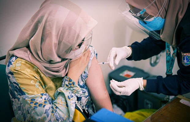 A woman receives a jab of vaccine against COVID-19 at Lebak Bulus Public Health Center in East Jakarta on August 23, 2021. (Photo: https://jakartaglobe.id/)