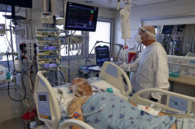 Nhân viên y tế điều trị cho bệnh nhân COVID-19 tại trung tâm y tế ở Tel Aviv, Israel. Ảnh: AFP/ TTXVN