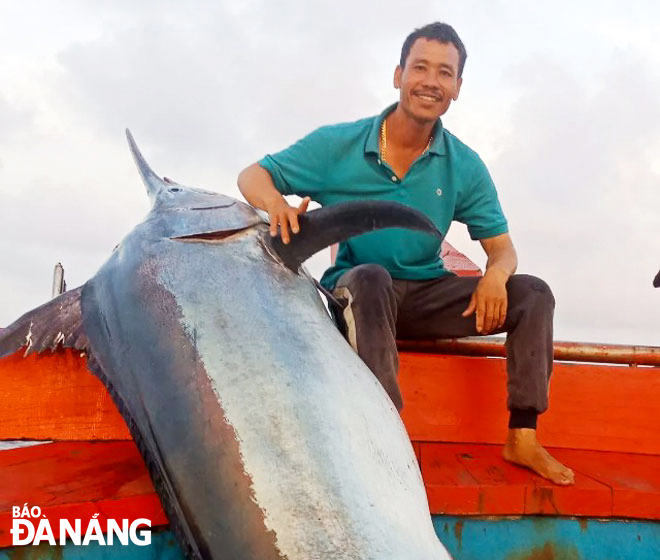 Fisherman Le Van Thien and 200kg sailfish caught in the Hoang Sa waters. Photo: TRAN THANG