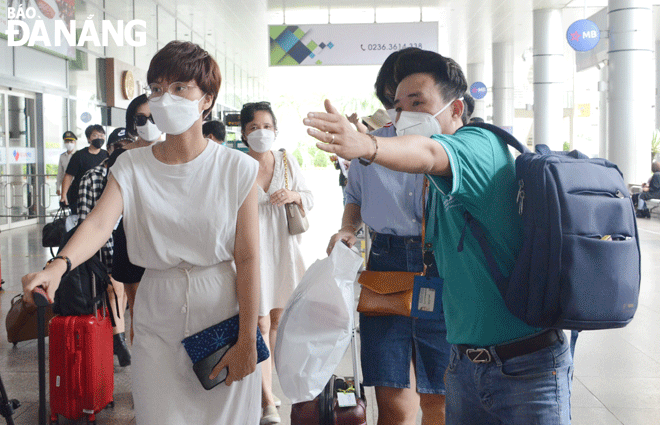 Da Nang’s tourism industry will improve its indicators to attract more visitors in the coming time. A tour guide (right) picks up and instruct his guests in groups at the Da Nang airport. Photo: NHAT HA