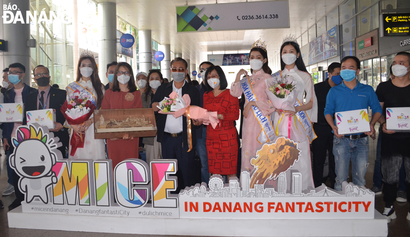 A representative from the Da Nang Department of Tourism (5th right) presenting congratulatory flowers to welcome the delegation of M.I.C.E visitors at the Da Nang Airport. Photo: THU HA