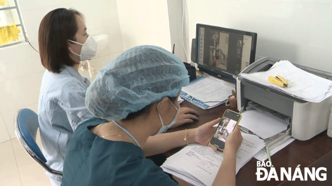 The application of information technology, changing the way of handling procedures for those infected with COVID-19 helps medical stations reduce the overload. The staff of the Tho Quang Ward Medical Station in Son Tra District verify a sent-via-Zalo video showing the process of a COVID-19 test conducted by a COVID-19 patient during home-based treatment. (Photo taken on March 9). Photo: PHAN CHUNG