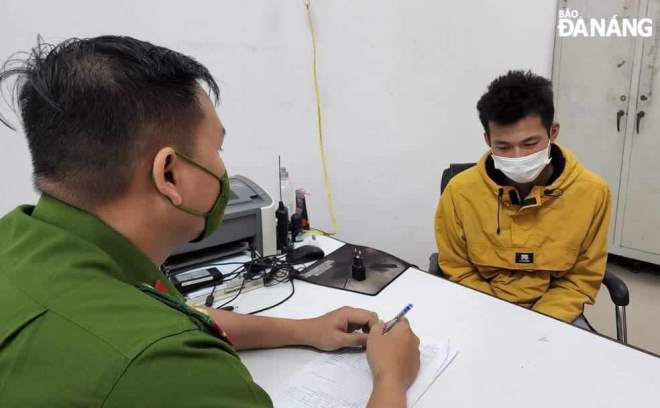 Suspect Dang Duc Trong (right) is seen at the police station. Photo: L.H