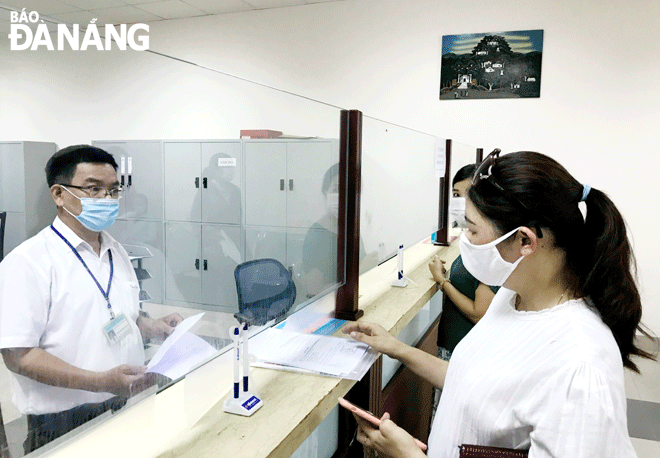 Production and business activities have gradually recovered, creating momentum for revenue collections to prosper. An officer of the Da Nang Tax Department (left) handles tax procedures and policies for citizens at the ‘One-stop shop’ unit. Photo: M.QUE