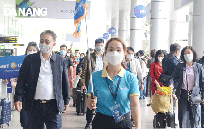 Da Nang’s tourism industry has prepared infrastructure and human resources to welcome tourists and M.I.C.E guests in particular. The tour guide (middle) welcomes and takes a group of tourists to a local hotel. Photo: THU HA