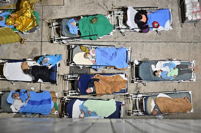 Người dân ngủ đêm tạm bên ngoài trung tâm y tế Caritas ở Hong Kong, Trung Quốc trong bối cảnh các bệnh viện bị quá tải do số ca mắc COVID-19 tăng đột biến, ngày 16/2/2022. Ảnh: AFP/TTXVN