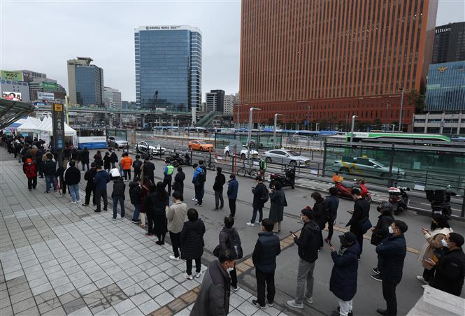 Người dân xếp hàng chờ xét nghiệm COVID-19 tại Seoul, Hàn Quốc, ngày 14/3/2022. Ảnh: Yonhap/ TTXVN