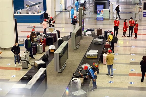 Passengers pick up their luggage at Noi Bai aiport's international terminal. (Photo: VNA)