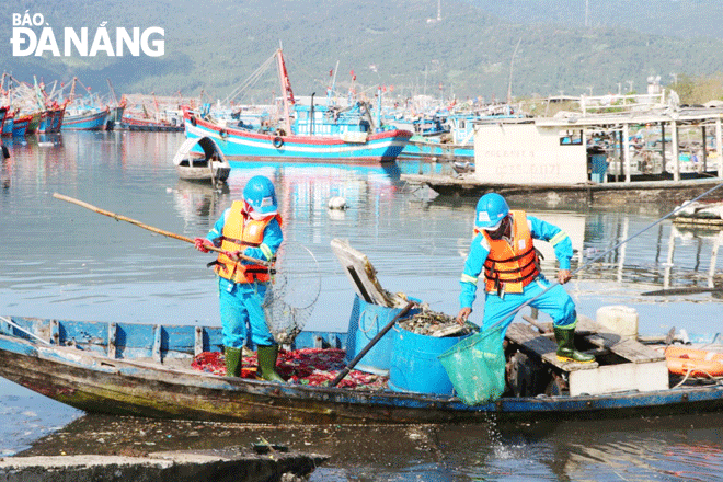 Workers of the Central Region branch of the Hai Noi-based Urban Environment Co., Ltd., (URENCO collect garbage at the Tho Quang fishing wharf. Photo: TRONG HUNG