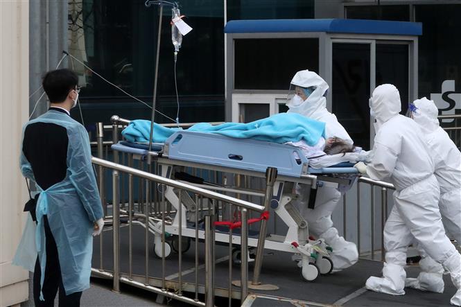 Nhân viên y tế chuyển bệnh nhân Covid-19 tới bệnh viện ở Seoul, Hàn Quốc, ngày 11/3/2022. Ảnh: THX/ TTXVN