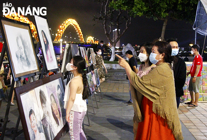 Visitors admire artworks on display at the ‘Da Nang - the return day’ exhibition. Photo: THIEN DUYEN