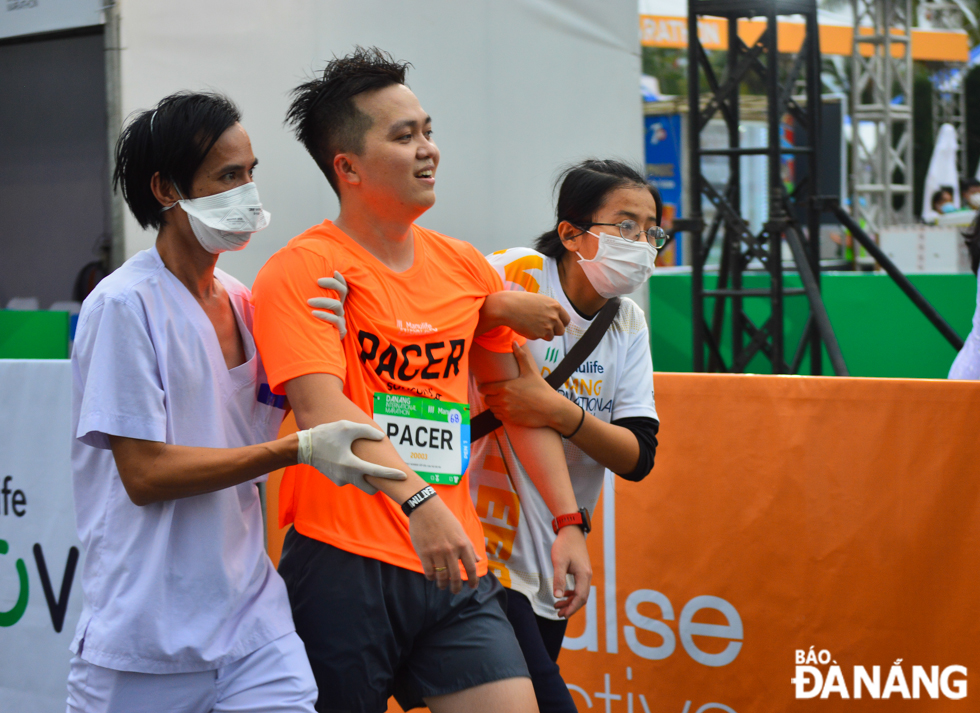  An injured athlete is medically assisted by volunteers after reaching the finish line.