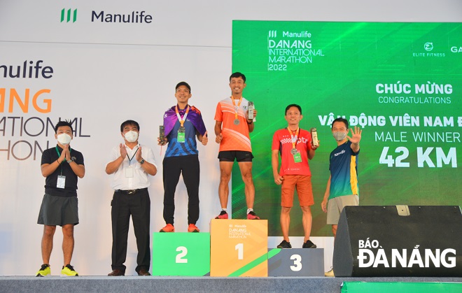 Mr Nguyen Trong Thao, the Deputy Director of the municipal Department of Culture and Sports (second from the left) presents rewards to winning runners in the 42km marathon race. Photo: T.K