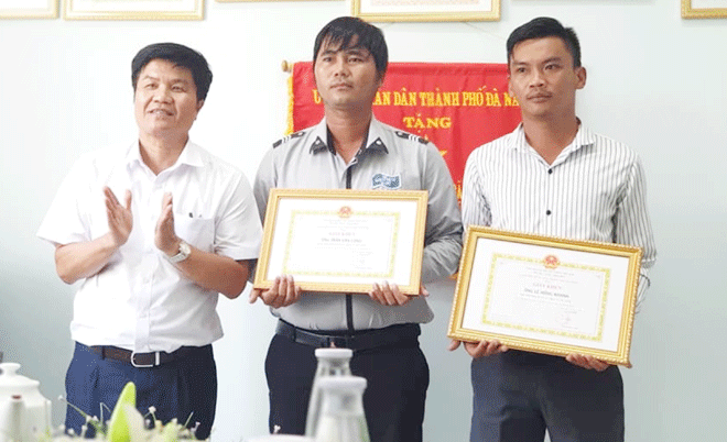 Mr. Le Hong Khanh (first right) and Mr Tran Van Cong (centre) receiving Certificates of Merit from a representative from the Da Nang Department of Tourism for returning valuable property to tourists in 2019. (Photo courtesy of characters)