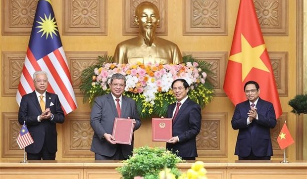 Vietnamese Prime Minister Pham Minh Chinh (first, right) and his Malaysian counterpart Ismail Sabri Yaakob (first, left) witness the exchange of a letter of intent on cooperation between the diplomatic academies of the two countries' foreign minsitries on March 21. (Photo: VNA)