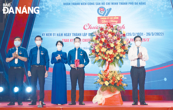 Phó Bí thư Thường trực Thành ủy Lương Nguyễn Minh Triết (bìa phải) trao lẵng hoa chúc mừng ngày thành lập Đoàn cho  đại diện Thành Đoàn. Ảnh: TS	