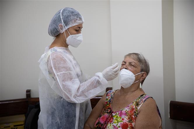 Nhân viên y tế lấy mẫu xét nghiệm COVID-19 cho người dân tại Rio de Janeiro, Brazil, ngày 16/3/2022. Ảnh: THX/ TTXVN