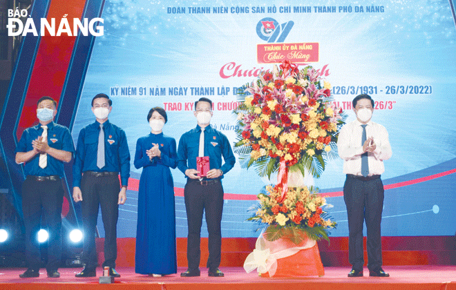 Standing Deputy Secretary of the Da Nang Party Committee cum Chairman of the municipal People's Council Luong Nguyen Minh Triet (first right) presenting a bouquet of flowers to congratulate the municipal Youth Union on their special day. Photo: T.S