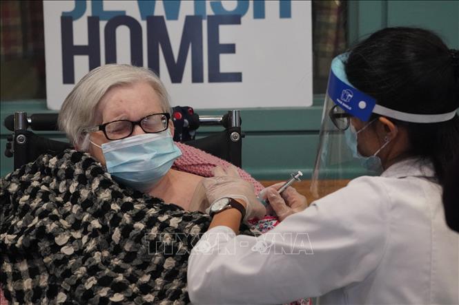 Nhân viên y tế tiêm vaccine phòng Covid-19 của Pfizer/BioNTech cho người cao tuổi tại New York, Mỹ. Ảnh: AFP/TTXVN