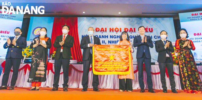 Đại diện Hội Doanh nghiệp quận Hải Châu đón nhận cờ do Phòng Thương mại và  Công nghiệp Việt Nam (VCCI) tặng vì có thành tích xuất sắc trong công tác hỗ trợ và  phát triển cộng đồng doanh nghiệp tại địa phương. Ảnh: YÊN THỦY