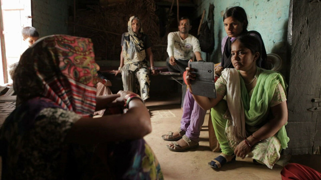Các nữ nhà báo Ấn Độ dùng điện thoại để ghi hình phỏng vấn một người dân nghèo. Ảnh: Idfa.nl