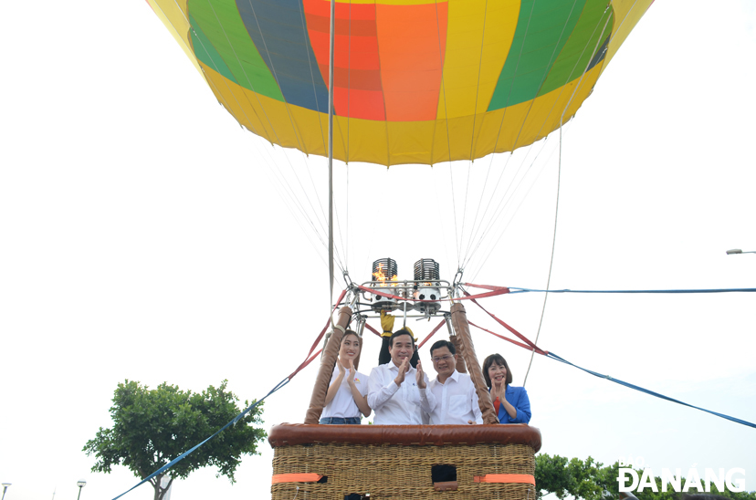 Chủ tịch UBND thànnh phố Lê Trung Chinh (thứ 2 từ trái sang) và Phó Chủ tịch UBND thành phố Trần Phước Sơn (thứ 2 từ phải sang) trải nghiệm bay khinh khí cầu. Ảnh: THU HÀ
