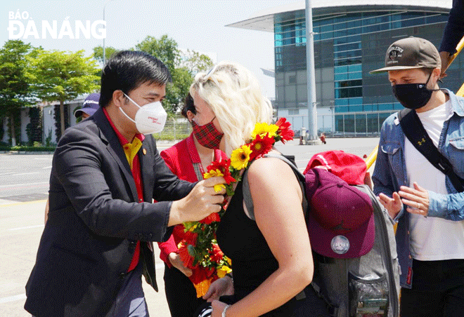 Du khách trên chuyến bay quốc tế đầu tiên tới Đà Nẵng vào trưa 27-3 được đại diện Hãng hàng không Vietjet tặng quà, chào đón ngay khi xuống khỏi máy bay. Ảnh: THU HÀ