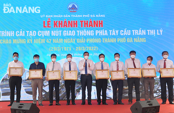 Chủ tịch UBND thành phố Lê Trung Chinh (thứ 5 từ trái sang) trao Bằng khen của UBND thành phố cho các tổ chức, cá nhân có thành tích xuất sắc trong xây dựng công trình). Ảnh: THÀNH LÂN