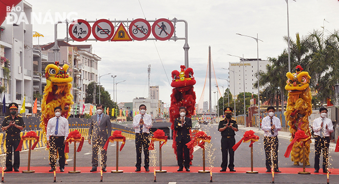 Da Nang Party Committee Secretary Nguyen Van Quang (5th, left), Standing Deputy Secretary Luong Nguyen Minh Triet (2nd, right), and Chairman of the municipal People's Committee Le Trung Chinh (4th, left) attending the ribbon cutting ceremony at the traffic infrastructure project at western end of the Tran Thi Ly Bridge. Photo: THANH LAN