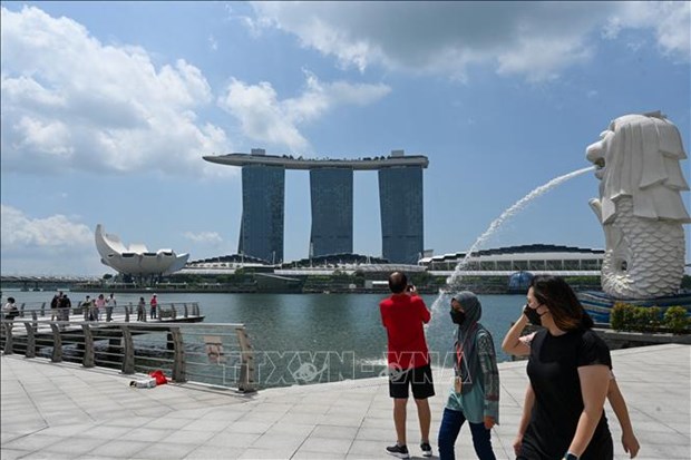 People wear masks to prevent the spread of COVID-19 in Singapore on March 24, 2022. (Photo: AFP/VNA)