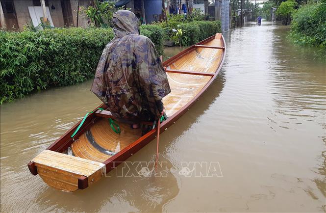 Nhiều tuyến giao thông tại huyện Quảng Điền, Thừa Thiên - Huế bị ngập, người dân phải di chuyển bằng thuyền. Ảnh: TTXVN phát