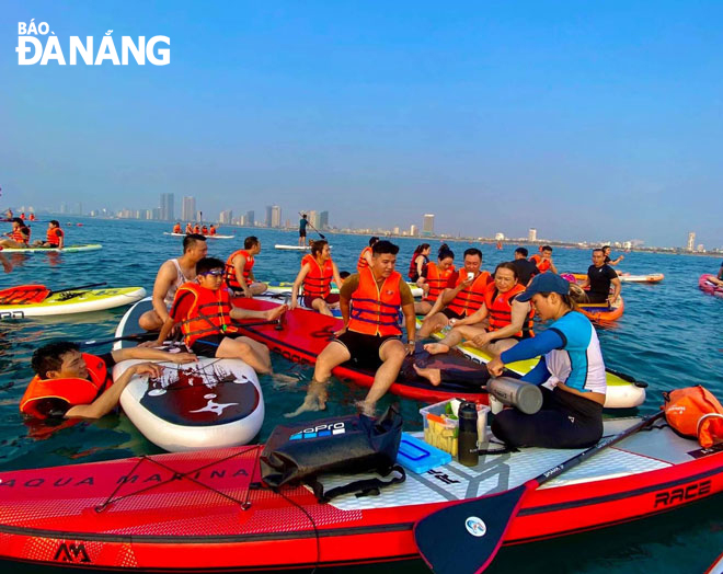 A group of tourists experiencing stand-up paddle boarding (SUP) on a Da Nang Beach. Photo:T.Y