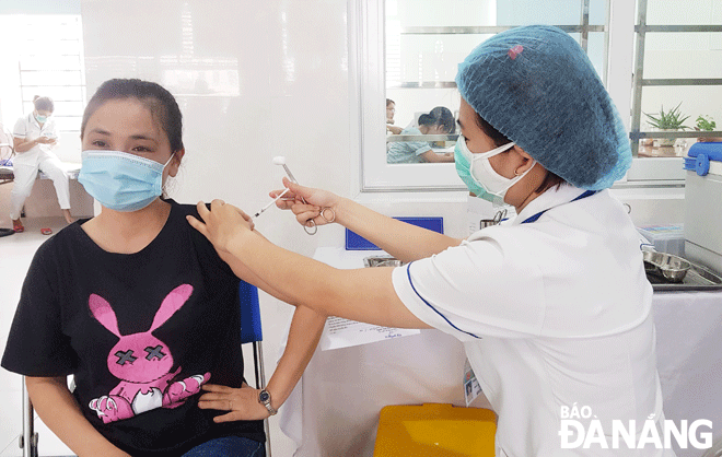 A health care worker administered a booster shot in early 2022 in Ngu Hanh Son District. Photo: PHAN CHUNG